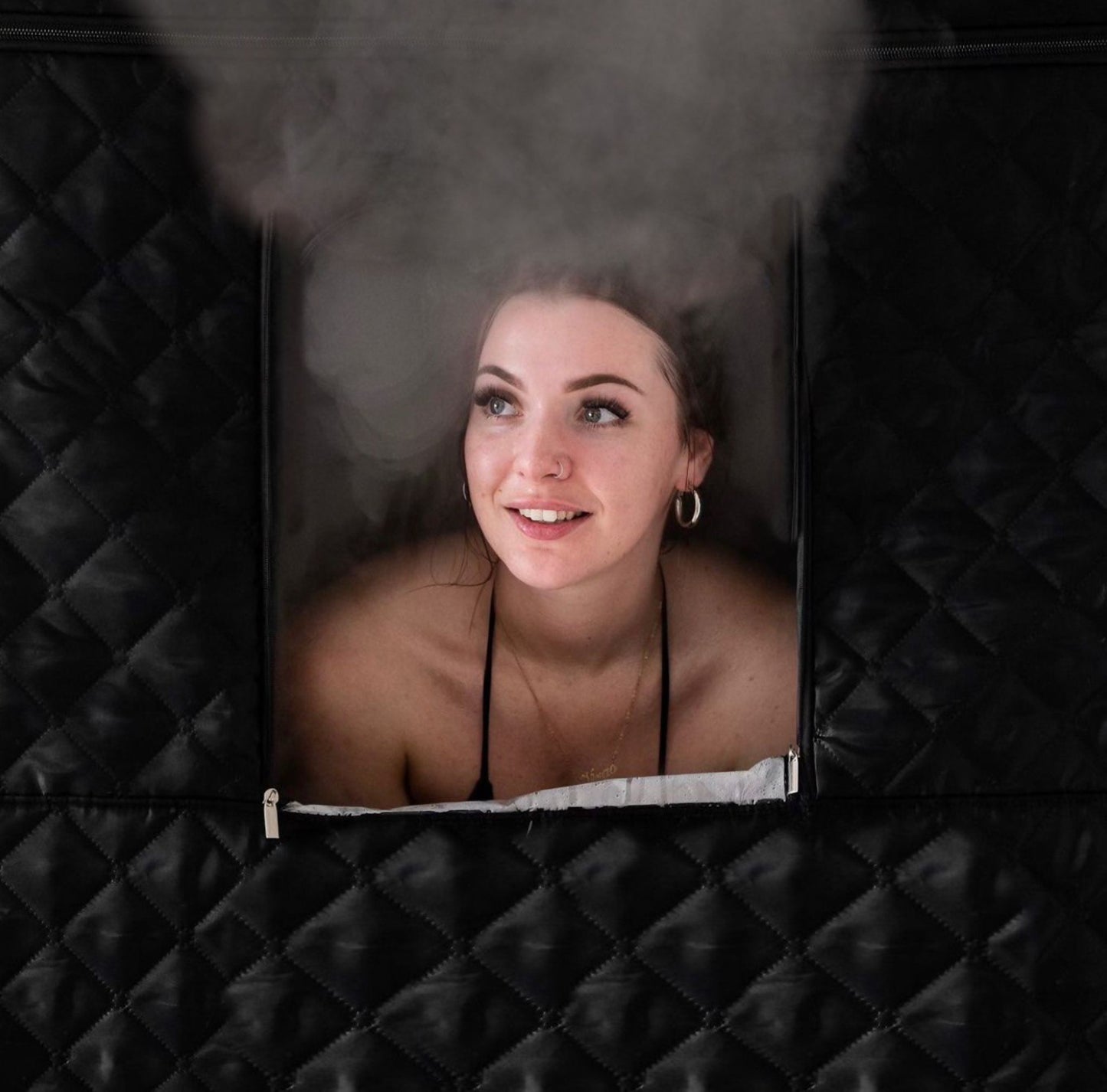 Person enjoying the AuraPro portable sauna, relaxing in comfort and wellness.