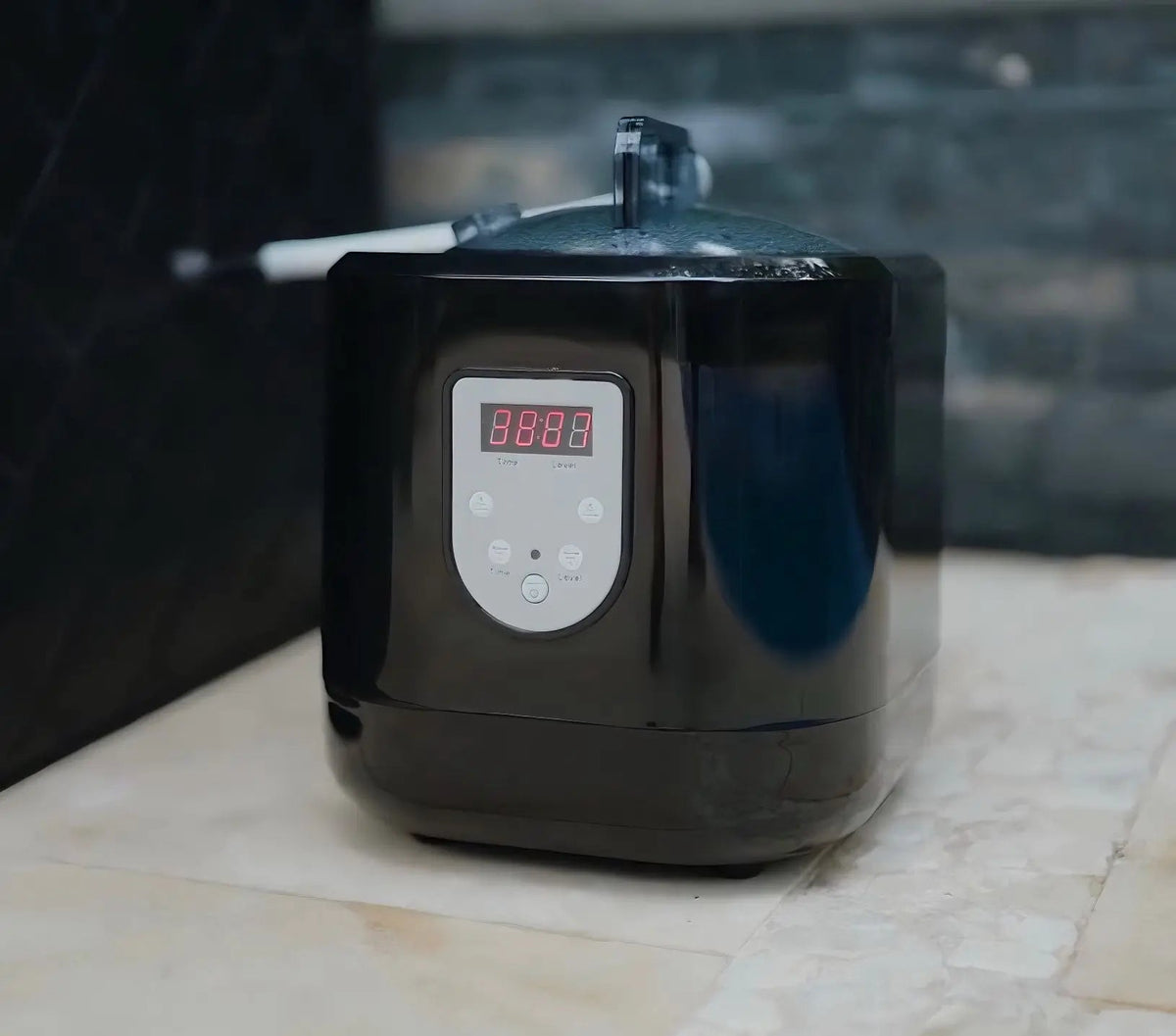 Black electronic device with digital display on a marble surface